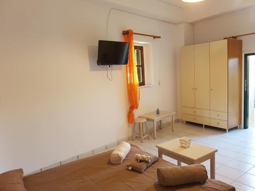 un soggiorno con divano e TV a parete di Faiakas ad Ágios Matthaíos