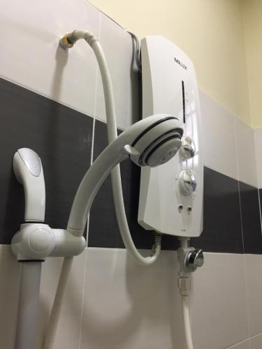 a hair dryer on a wall in a bathroom at Raina Muslim Homestay Perlis in Arau