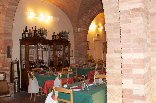 a dining room with green tables and chairs with wine bottles at Le Vecchie Cantine in Chianni
