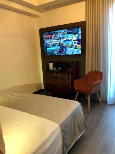 a hotel room with a bed and a flat screen tv at Dimora Augusteo in Naples