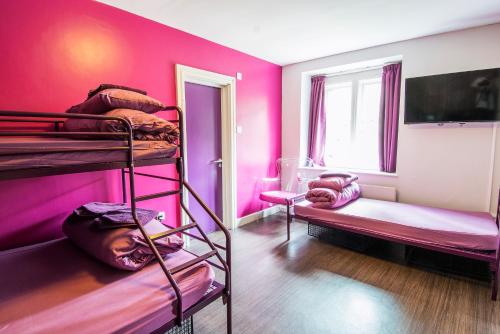 two bunk beds in a room with pink walls at Safestay London Kensington Holland Park in London
