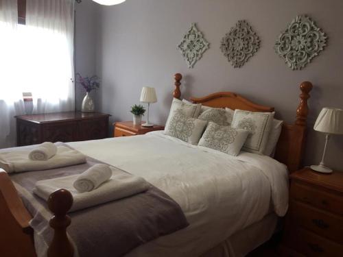 a bedroom with a large bed with towels on it at Póvoa City Center Apartment in Póvoa de Varzim