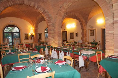 a dining room with green tables and chairs at Le Vecchie Cantine in Chianni
