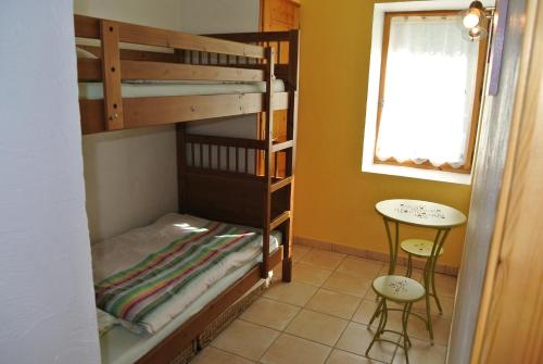 una habitación con dos literas y una mesa en Le Refuge, en Saint-Gervais-les-Bains