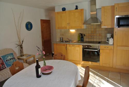 - une cuisine avec une table et une bouteille de vin dans l'établissement Le Refuge, à Saint-Gervais-les-Bains