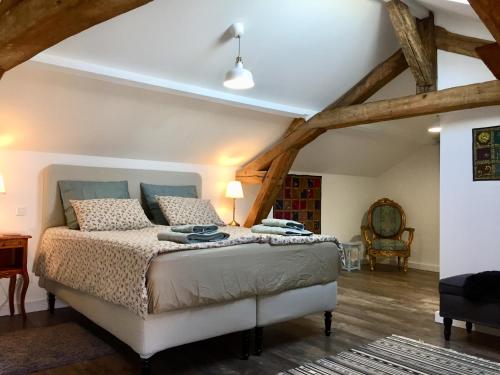 シャヴェーニュにあるBoutique Farmhouse Cottages with Pool, 6 Bedrooms - Angulus Ridet (Loire Valley)のベッドルーム1室(梁出し天井付)