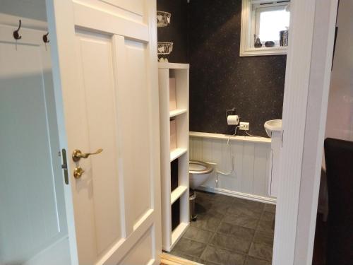 Volda的住宿－Huset på hauen，一间带卫生间和白色门的浴室