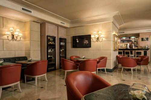 a restaurant with red chairs and tables and a bar at Hotel Capitol Milano in Milan