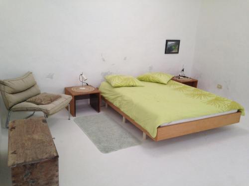 a bedroom with a large bed and a chair at Patio I in La Asomada