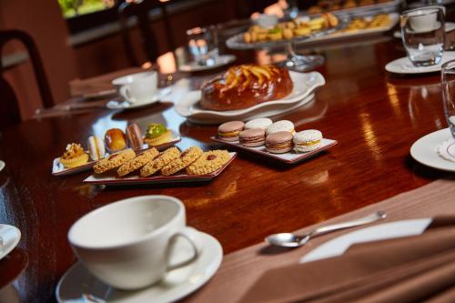 a table with plates of pastries and a cup of coffee at Albergo Trattoria Il Leone in Pomponesco