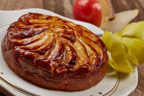 a cake on a plate with apples on a table at Albergo Trattoria Il Leone in Pomponesco