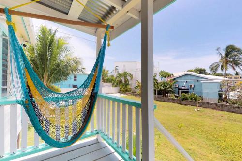 a hammock on the porch of a house at Casa DV Cabanas in Caye Caulker
