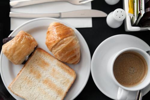 un piatto con due fette di pane e una tazza di caffè di Soho Boutique Congreso a Madrid