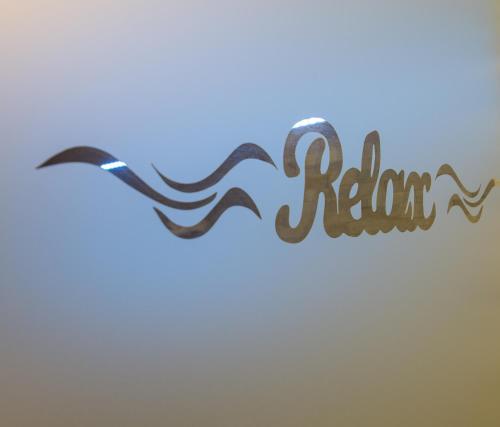 a sign that says relax with a wave at Wellness Apartmán Relax in Český Těšín