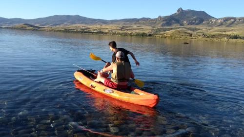 a man and a woman in a kayak in the water at Cabañas Boca del Chimehuín in Junín de los Andes