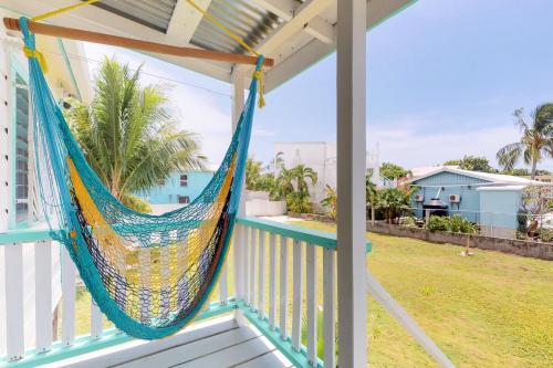a hammock on the porch of a house at Casa DV Cabanas in Caye Caulker