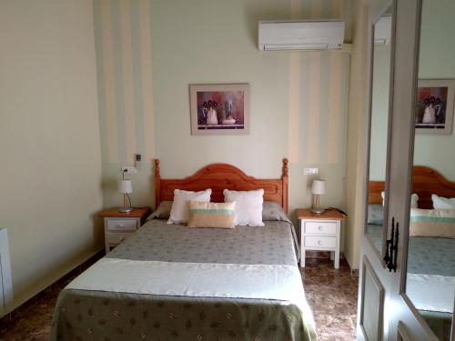 1 dormitorio con 1 cama grande y 2 mesitas de noche en Hostal Rural Gloria en Graena