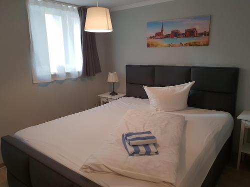 a bedroom with a bed with a towel on it at Appartement-Hotel Rostock in Rostock