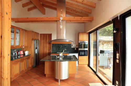 a kitchen with wooden cabinets and a stainless steel refrigerator at Mas Companyo - Vallespir - Céret - Grand Mas in Céret