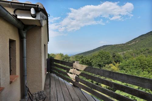 a wooden deck with a fence and mountains in the background at Mas Companyo - Vallespir - Céret - Grand Mas in Céret