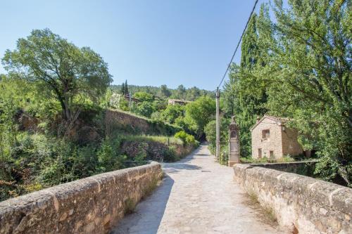 a stone bridge over a road with a building at La Casa de Los Moyas in Olba