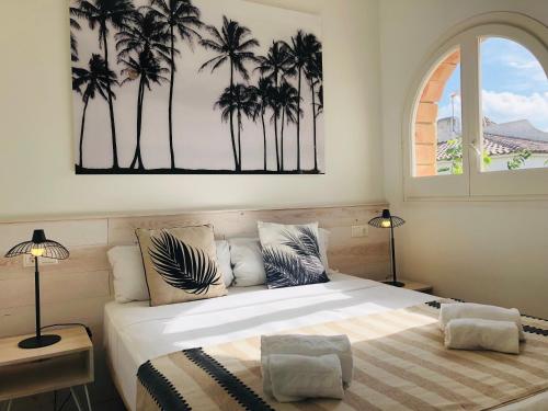 a bedroom with a bed with palm trees on the wall at Casa Acacia Mar in Cambrils