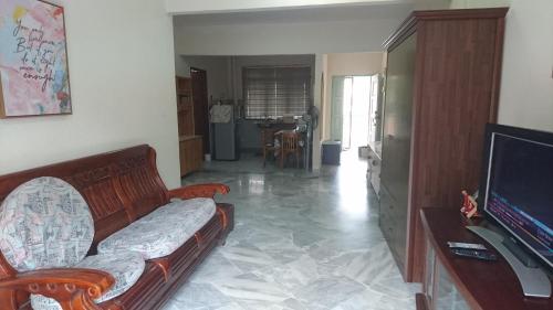 a living room with a couch and a flat screen tv at Family Beach Condo PD at Cocobay Resort Condominium in Port Dickson