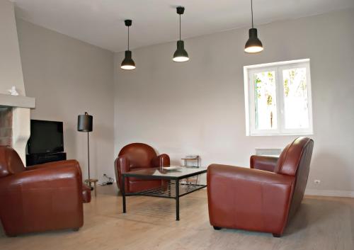 CauxにあるGite de Mougeresのリビングルーム(革張りの椅子、テーブル、テレビ付)