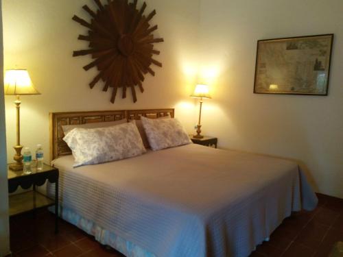 a bedroom with a bed with two lamps and a clock on the wall at Casa Marly in Xochitepec