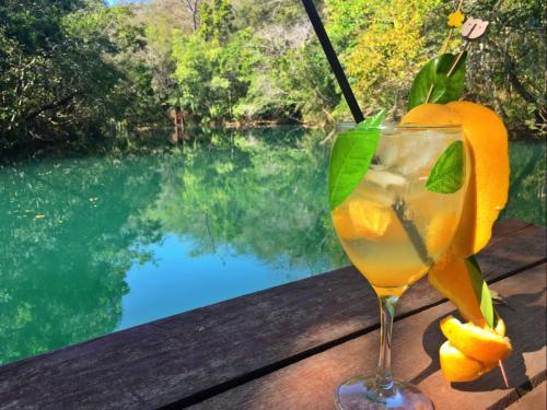 a glass of lemonade sitting on a table next to a pool at Pousada Boyrá in Bonito