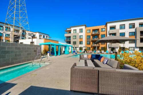 a pool with chairs and an umbrella and some buildings at Bluebird Suites in Menlo Park in Menlo Park