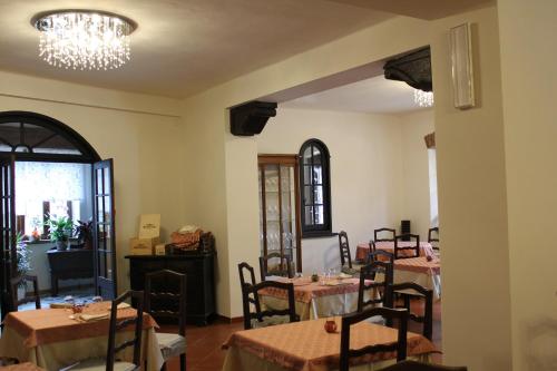a dining room with tables and chairs and a chandelier at Locanda Ponte Rosa in Garessio