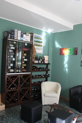 a room with a wine cabinet and a white chair at Locanda Ponte Rosa in Garessio