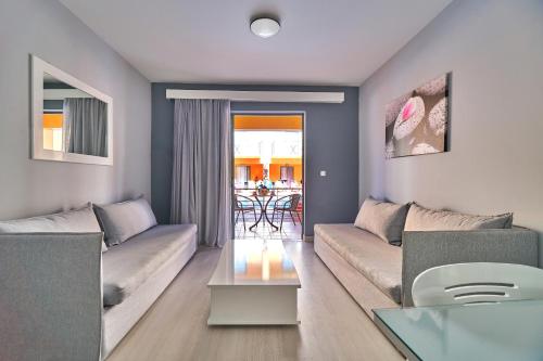 a living room with a couch and a table at Sunrise Village Hotel - All Inclusive in Plataniás