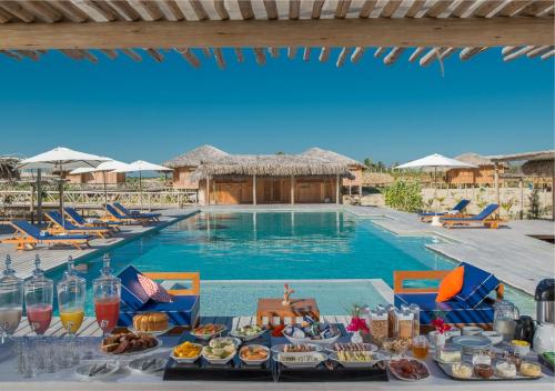 een tafel met eten naast een zwembad bij Jaguaribe Lodge e Kite in Fortim