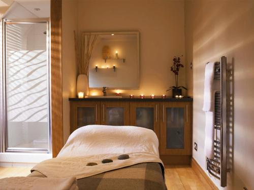 a bedroom with a bed and a mirror and a window at Macdonald Houstoun House in Livingston