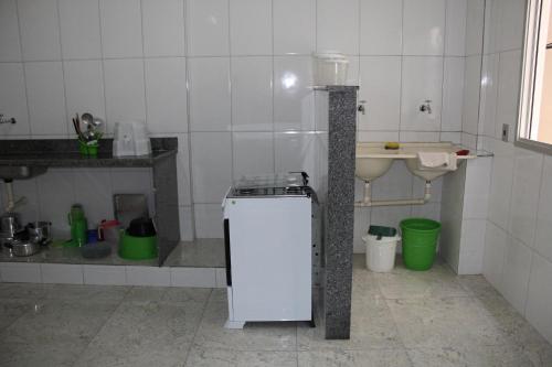 a small kitchen with a sink and a small refrigerator at Edifício San Jorge in Piúma