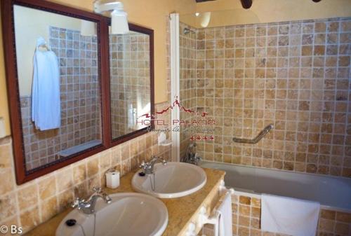 a bathroom with two sinks and a mirror at Palacio Marques de la Gomera in Osuna