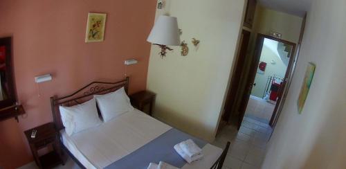 a bedroom with a bed and a lamp and a window at Ionio Sea Poros Studios in Mikros Gialos