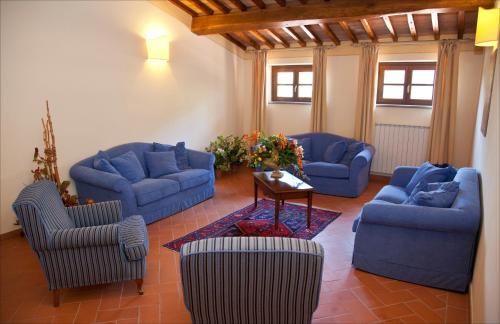 a living room with blue couches and a table at Le Vecchie Cantine in Chianni