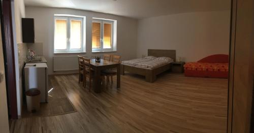 a living room with a table and a room with a bed at Ubytovanie Luky in Bojnice