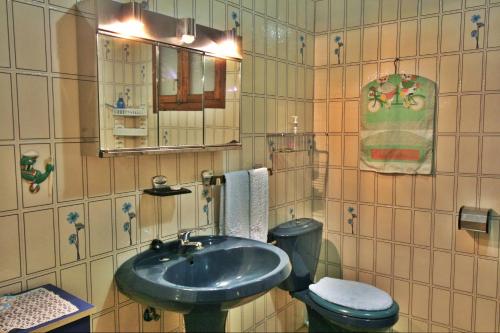 y baño con lavabo, aseo y espejo. en Casa Añon, en Cabana de Bergantiños
