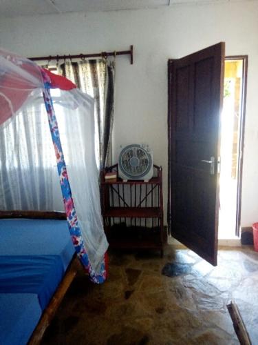 a living room with a blue couch and a window at Mango Lodge MSAMBWENI in Kisimachande