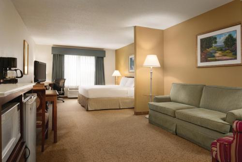 a hotel room with a bed and a couch at Country Inn & Suites by Radisson, Mankato Hotel and Conference Center, MN in Mankato