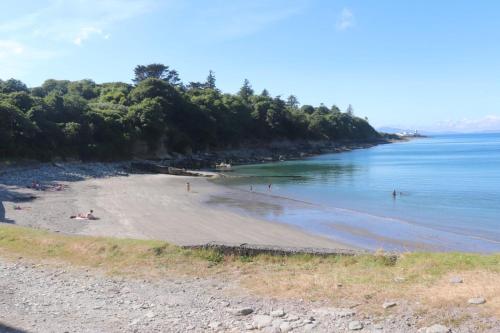 a beach with people on the sand and the water at Boss’s farmhouse in Valentia Island
