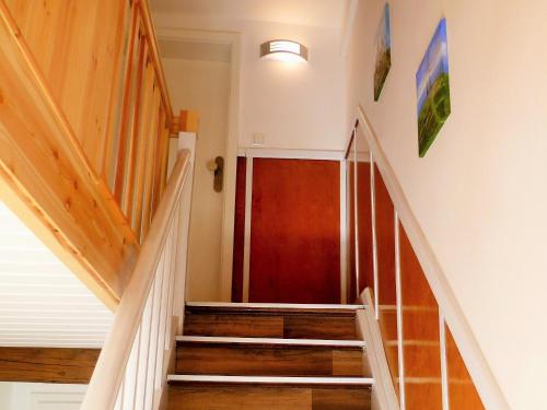 een hal met een trap en een rode deur bij Ferienwohnung Schreiberstraße in Wernigerode