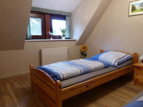 ヴィークにあるFerienwohnungen Strandweg 6のベッドルーム1室(青いシーツと窓付)