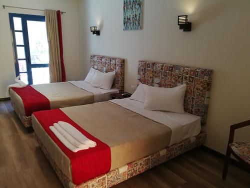 a hotel room with two beds and a window at Cordoba Suites in Hurghada