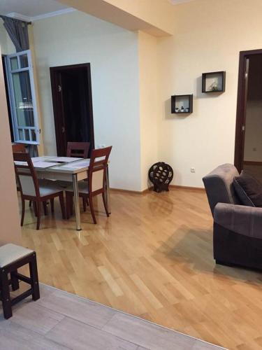 a living room with a table and chairs and a couch at Asterias Apartment in Tbilisi City