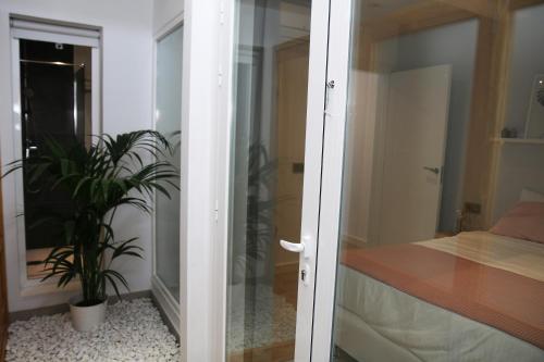 una porta a vetri che conduce a una camera da letto con una pianta di Apartamento Valeria a Puerto del Carmen